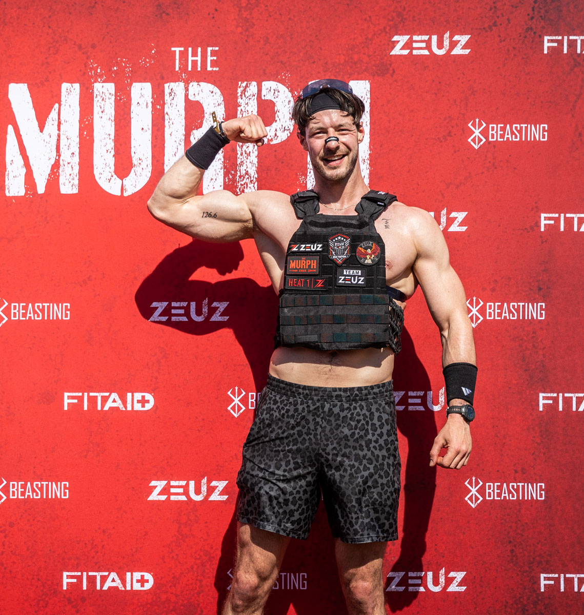 The coach is posing at the MURPH banner.